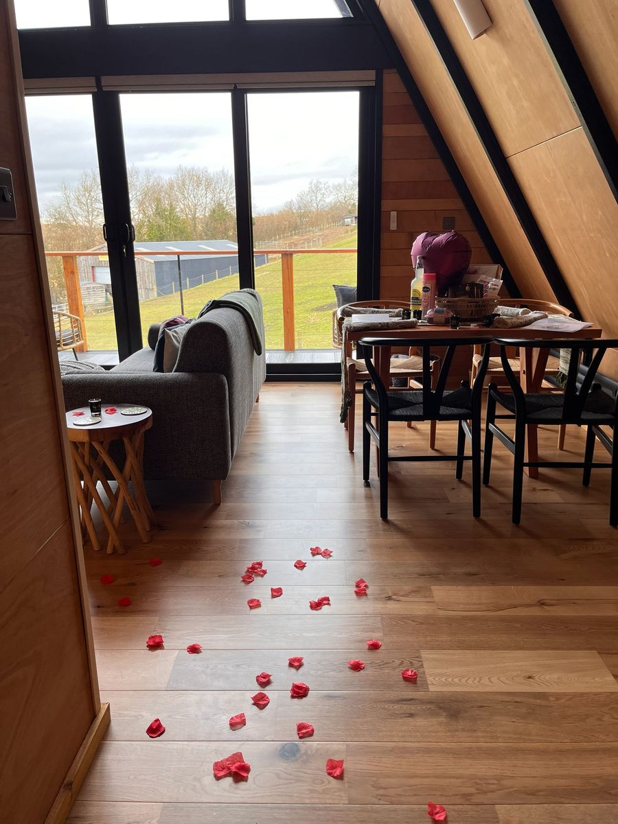 Open-plan lodge living and dining area set up with a welcome hamper for arriving guests