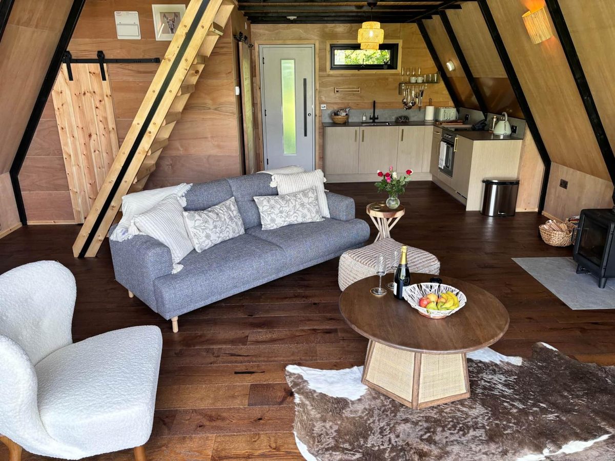 Open-plan living space of an A-frame holiday lodge, cleaned and styled for the next guest